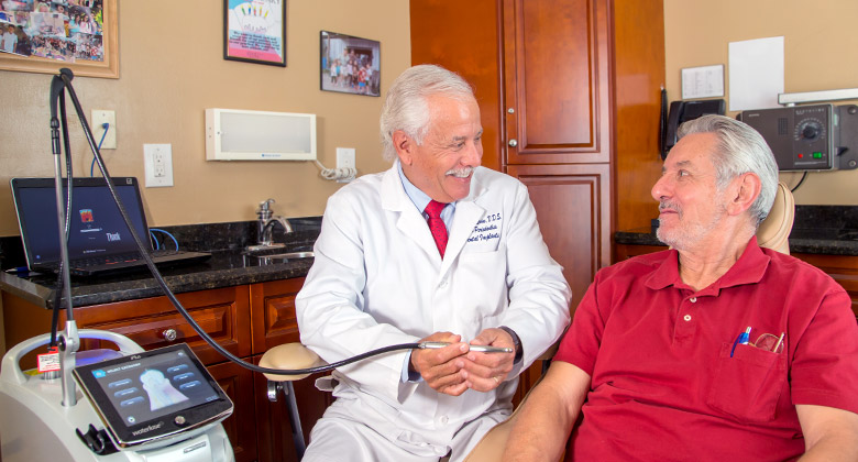Doctor showing patient dental laser